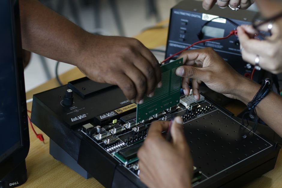 A student testing a circuit board in an electrical engineering lab